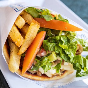 Chicken gyro wrap with fries, lettuce, and tomato in a paper cone